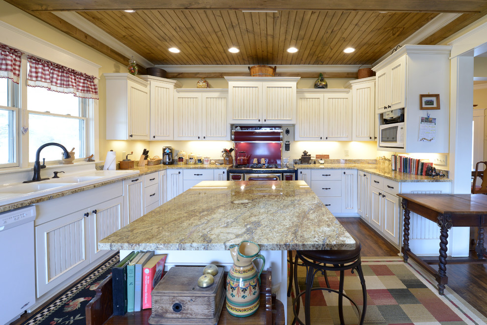 Bild på ett stort lantligt kök, med en rustik diskho, skåp i shakerstil, vita skåp, granitbänkskiva, beige stänkskydd, stänkskydd i sten, färgglada vitvaror, mörkt trägolv och en köksö