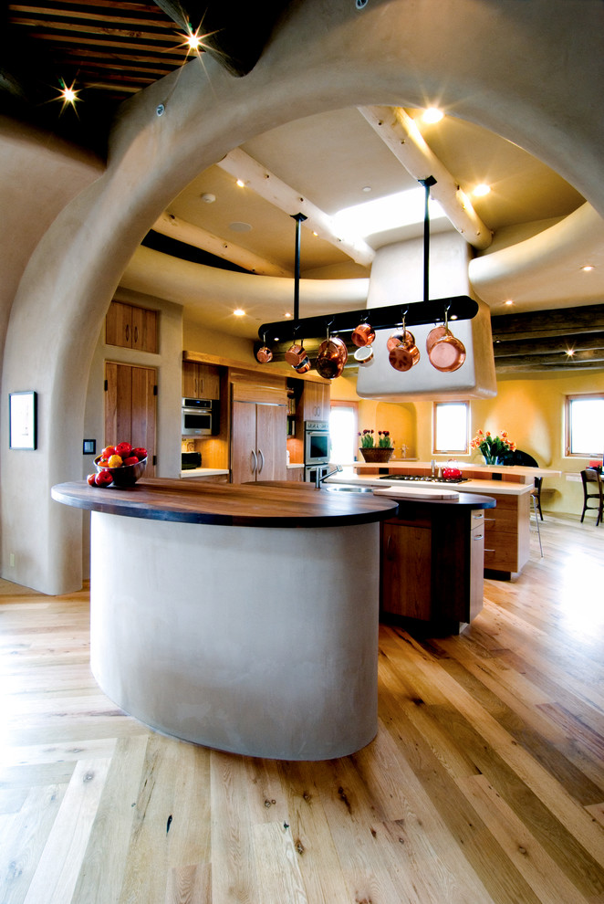 Пример оригинального дизайна: кухня в стиле фьюжн с плоскими фасадами, фасадами цвета дерева среднего тона, деревянной столешницей, техникой под мебельный фасад, двумя и более островами и полом из бамбука
