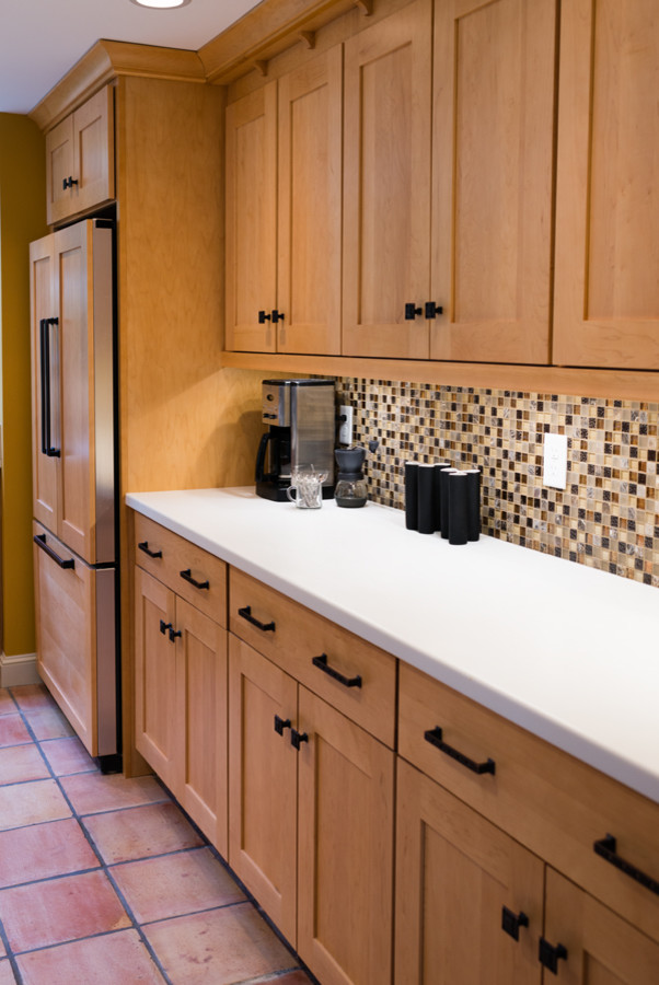 Mid-sized eclectic u-shaped terra-cotta tile kitchen photo in Boston with an undermount sink, recessed-panel cabinets, light wood cabinets, solid surface countertops, multicolored backsplash, glass tile backsplash, stainless steel appliances and an island