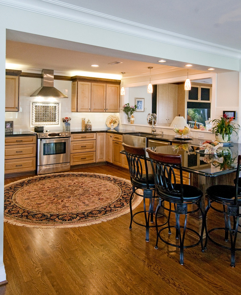 Eat-in kitchen - large modern u-shaped medium tone wood floor eat-in kitchen idea in Wilmington with an undermount sink, raised-panel cabinets, light wood cabinets, granite countertops, white backsplash, ceramic backsplash, stainless steel appliances and an island