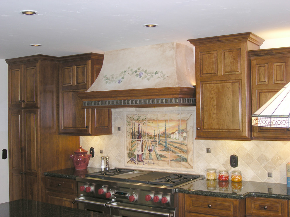 Bild på ett stort medelhavsstil kök, med en dubbel diskho, luckor med upphöjd panel, skåp i mellenmörkt trä, granitbänkskiva, beige stänkskydd, stänkskydd i stenkakel, rostfria vitvaror, ljust trägolv, en köksö och brunt golv