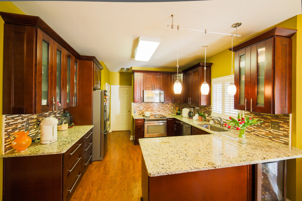 Idéer för ett avskilt, mellanstort klassiskt u-kök, med en undermonterad diskho, luckor med infälld panel, skåp i mörkt trä, granitbänkskiva, flerfärgad stänkskydd, stänkskydd i stickkakel, rostfria vitvaror, ljust trägolv, en halv köksö och brunt golv