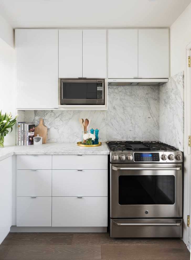 This is an example of a small traditional l-shaped kitchen in Toronto with flat-panel cabinets, white cabinets, marble worktops, stone tiled splashback, stainless steel appliances and a breakfast bar.