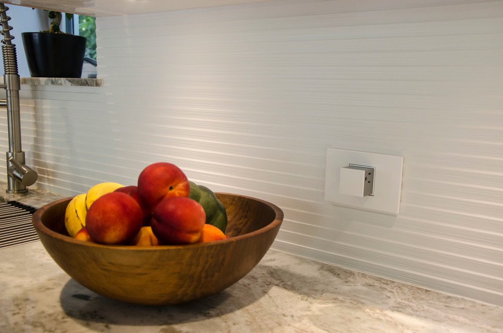 This is an example of a large contemporary single-wall open plan kitchen in Miami with a submerged sink, flat-panel cabinets, white cabinets, granite worktops, white splashback, porcelain splashback, stainless steel appliances, slate flooring and an island.