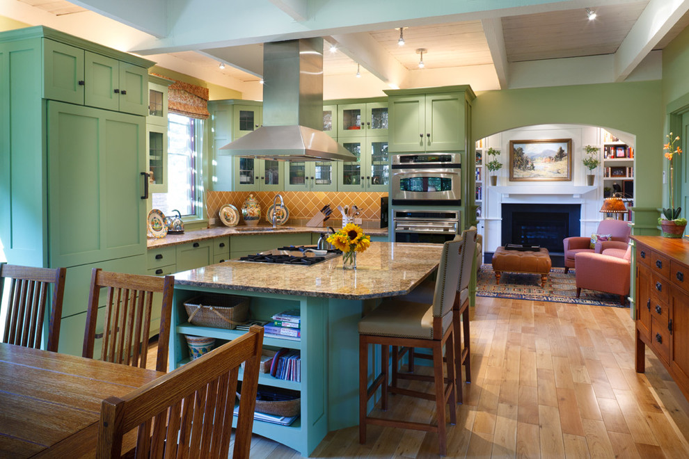 Inspiration for a mid-sized farmhouse l-shaped light wood floor and brown floor eat-in kitchen remodel in Boston with green cabinets, beige backsplash, paneled appliances, an undermount sink, shaker cabinets, granite countertops, ceramic backsplash and an island