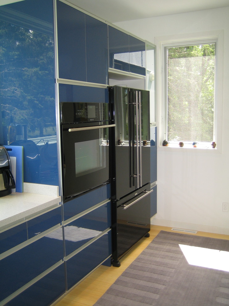 Zweizeilige Moderne Wohnküche mit blauen Schränken, schwarzen Elektrogeräten, Unterbauwaschbecken, flächenbündigen Schrankfronten, Laminat-Arbeitsplatte und hellem Holzboden in Minneapolis