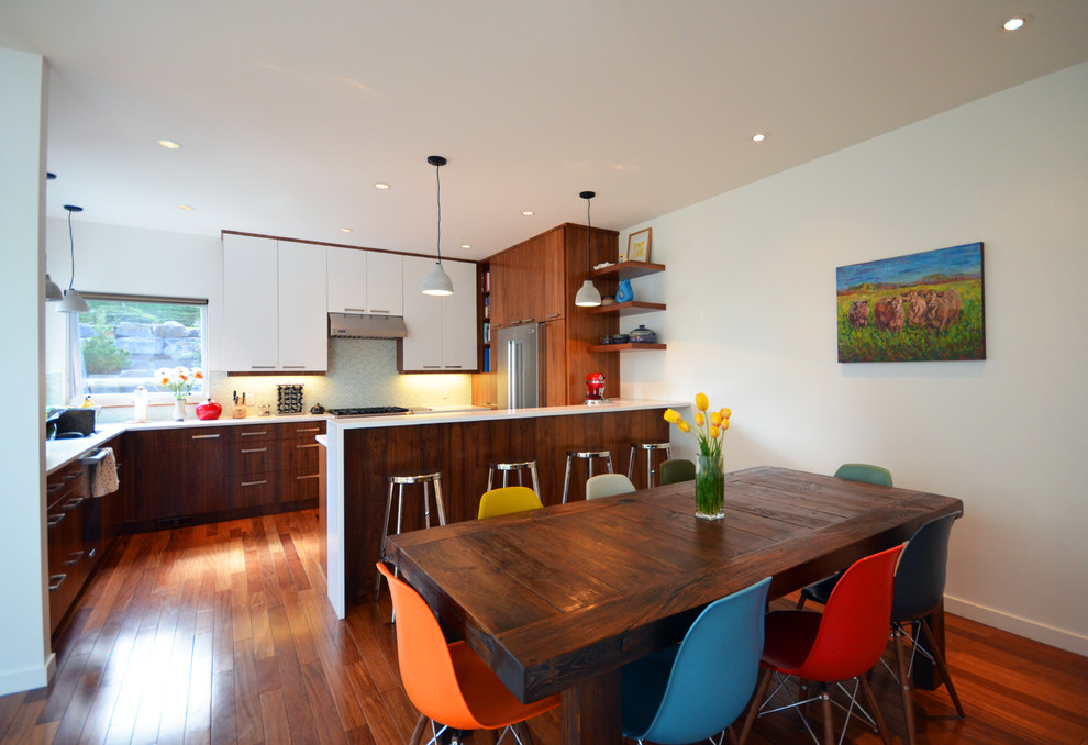Moderne Wohnküche in U-Form mit Unterbauwaschbecken, flächenbündigen Schrankfronten, hellbraunen Holzschränken, Quarzwerkstein-Arbeitsplatte, Küchenrückwand in Weiß und Küchengeräten aus Edelstahl in Calgary