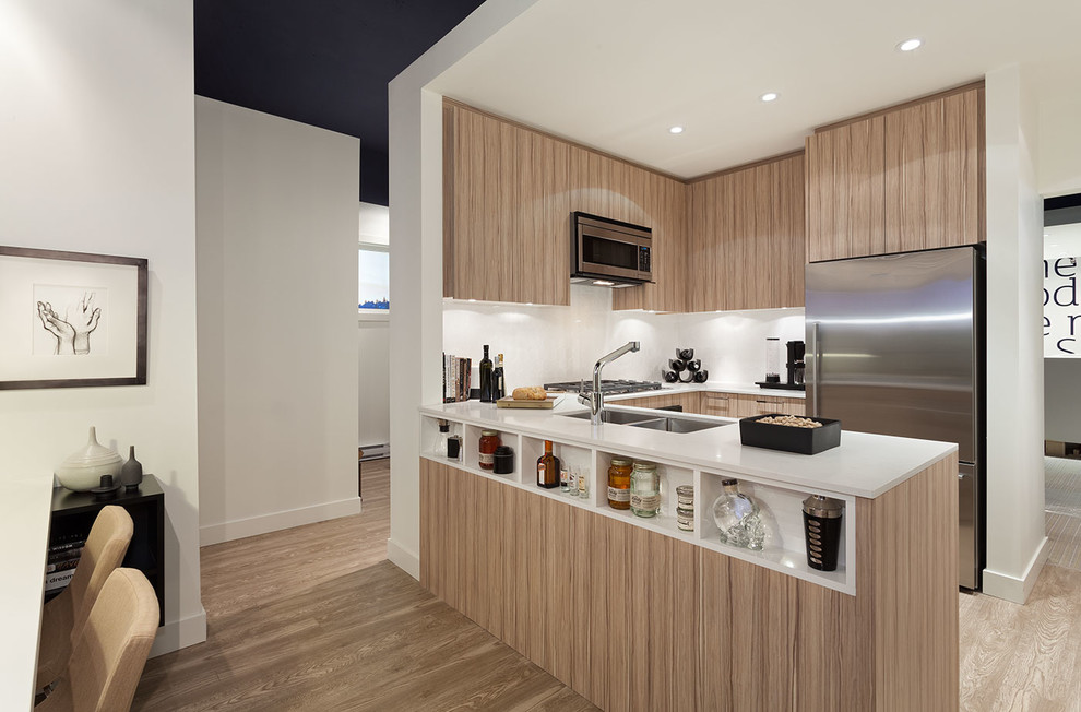 Example of a small minimalist u-shaped light wood floor open concept kitchen design in Vancouver with an undermount sink, flat-panel cabinets, light wood cabinets, quartzite countertops, white backsplash, ceramic backsplash, stainless steel appliances and an island