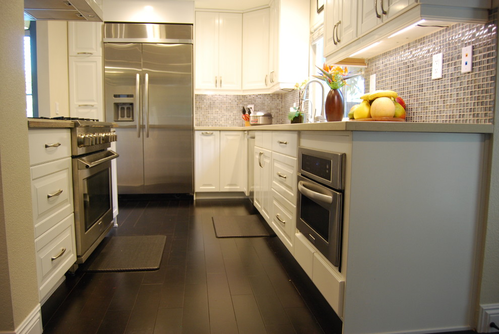Esempio di una cucina minimal di medie dimensioni con lavello sottopiano, ante a persiana, ante bianche, top in granito, paraspruzzi blu, elettrodomestici in acciaio inossidabile e parquet scuro