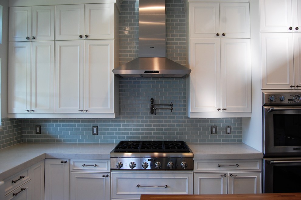 Example of a mid-sized arts and crafts u-shaped dark wood floor eat-in kitchen design in Orlando with a farmhouse sink, beaded inset cabinets, turquoise cabinets, quartz countertops, metallic backsplash, porcelain backsplash, stainless steel appliances and an island