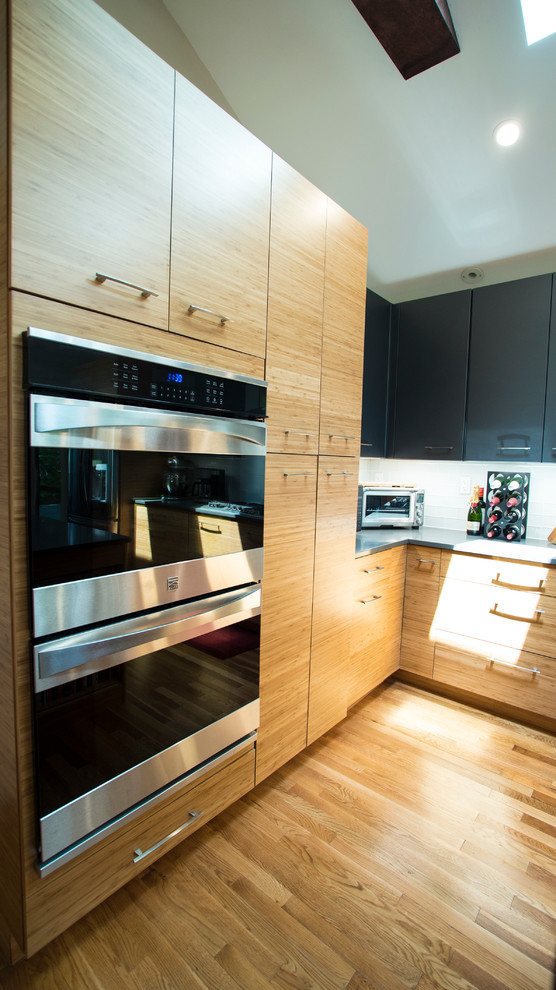 Exempel på ett mellanstort modernt grå grått kök, med en undermonterad diskho, släta luckor, skåp i ljust trä, bänkskiva i kvarts, grönt stänkskydd, stänkskydd i glaskakel, rostfria vitvaror, ljust trägolv och en köksö