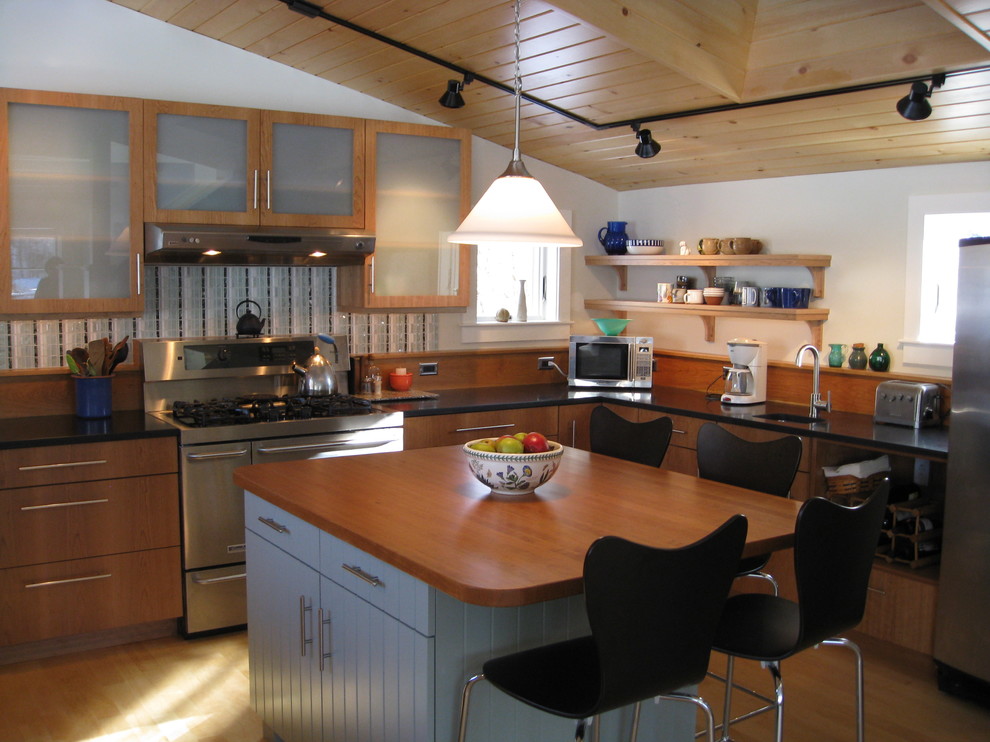Example of a large trendy u-shaped light wood floor open concept kitchen design in Portland Maine with an integrated sink, flat-panel cabinets, medium tone wood cabinets, granite countertops, brown backsplash and stainless steel appliances