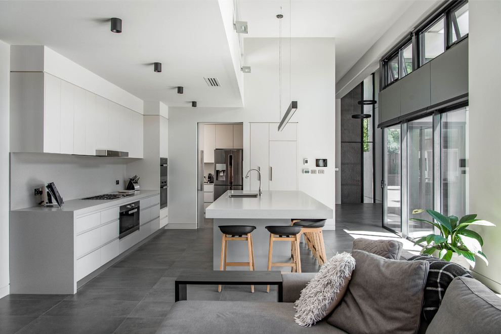 Offene Moderne Küche in L-Form mit Unterbauwaschbecken, flächenbündigen Schrankfronten, Küchenrückwand in Grau, Kücheninsel, grauem Boden und grauer Arbeitsplatte in Canberra - Queanbeyan