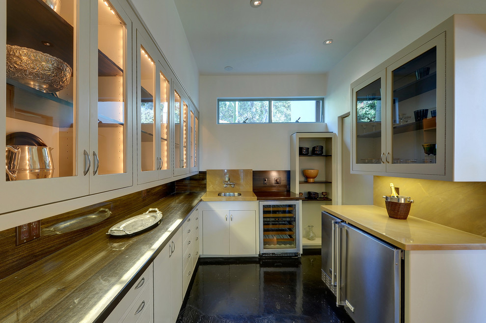 Idéer för att renovera ett avskilt, mellanstort funkis u-kök, med en undermonterad diskho, luckor med glaspanel, vita skåp, rostfria vitvaror och svart golv