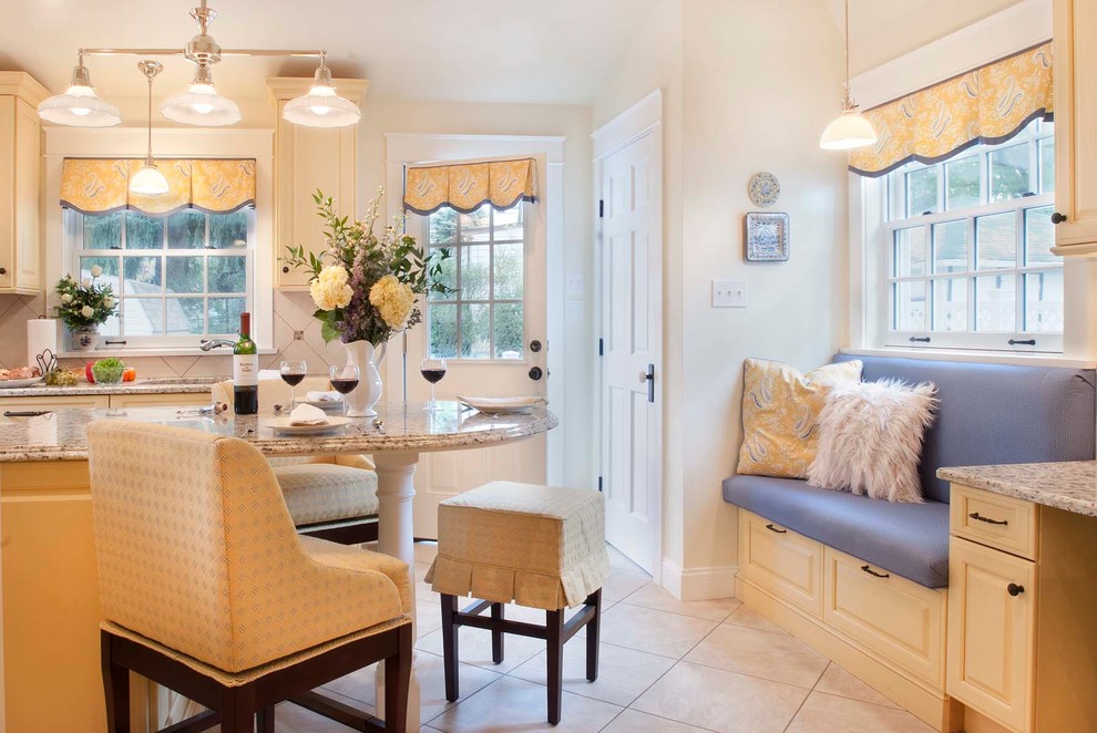Mid-sized elegant u-shaped porcelain tile eat-in kitchen photo in Philadelphia with an undermount sink, raised-panel cabinets, yellow cabinets, granite countertops, beige backsplash, porcelain backsplash, paneled appliances and an island