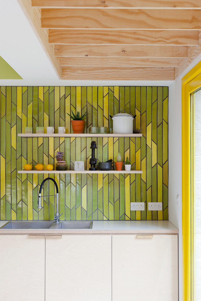 Пример оригинального дизайна: кухня в современном стиле с плоскими фасадами, желтым фартуком и фартуком из керамической плитки
