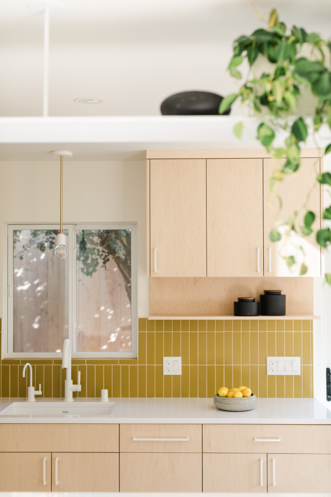 This is an example of a small scandi l-shaped enclosed kitchen in Los Angeles with beige cabinets, yellow splashback, ceramic splashback, white appliances, concrete flooring, no island, multi-coloured floors and white worktops.
