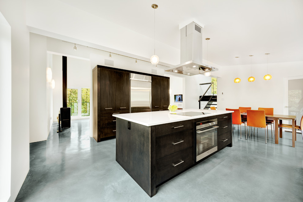 Стильный дизайн: кухня в стиле модернизм с техникой из нержавеющей стали, обеденным столом, плоскими фасадами и темными деревянными фасадами - последний тренд