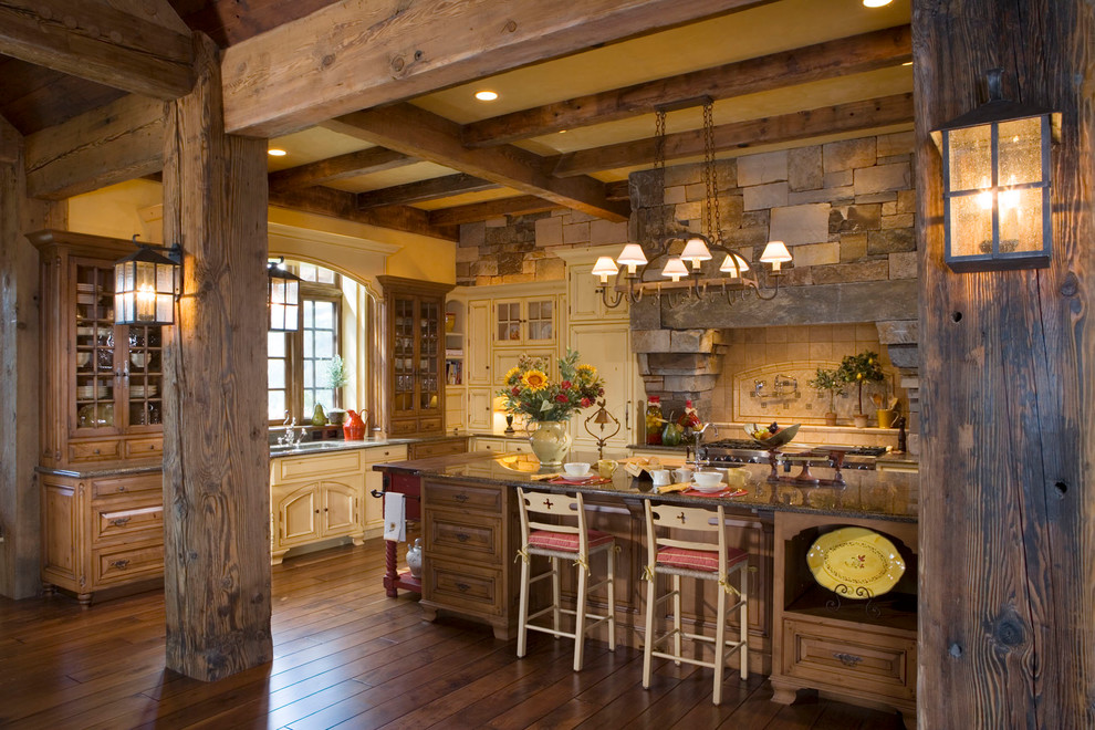 Rustikale Küche mit profilierten Schrankfronten, hellbraunen Holzschränken, Küchenrückwand in Beige und Küchengeräten aus Edelstahl in Sonstige
