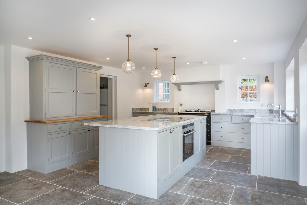 This is an example of a large country u-shaped kitchen/diner in Oxfordshire with a belfast sink, ceramic flooring and an island.