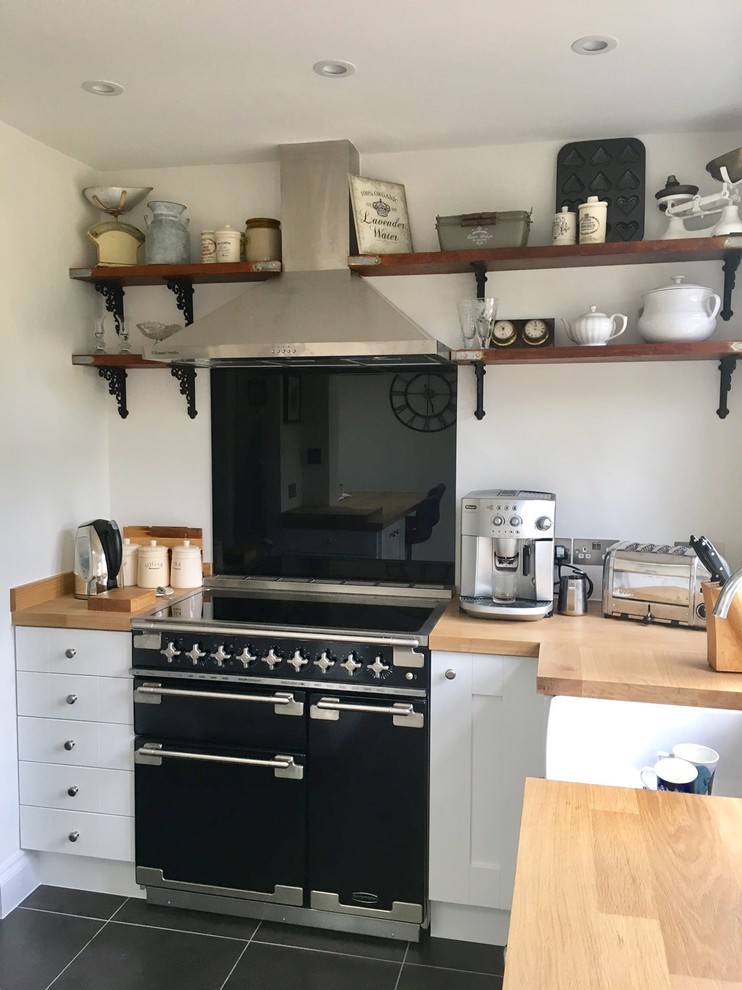 Design ideas for a small traditional kitchen in Essex with shaker cabinets, white cabinets, wood worktops and grey floors.