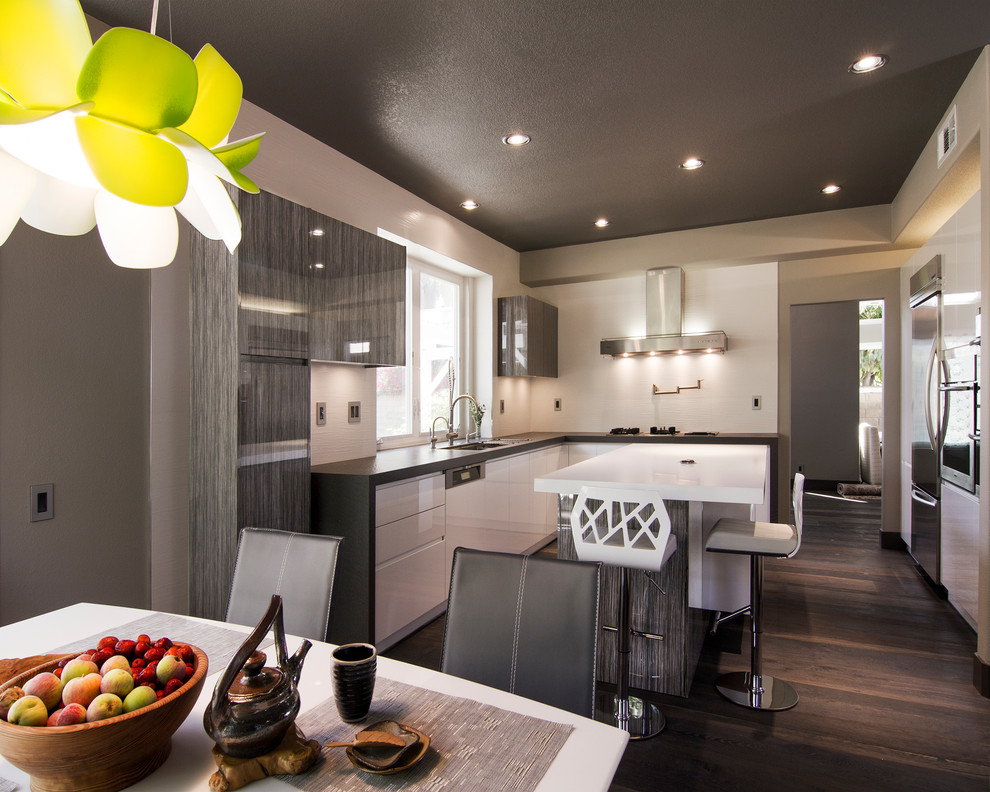 Eat-in kitchen - contemporary u-shaped eat-in kitchen idea in Los Angeles with an undermount sink, flat-panel cabinets, quartz countertops, white backsplash, porcelain backsplash and stainless steel appliances