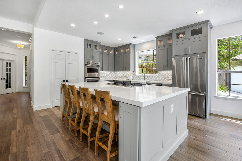 Exempel på ett mellanstort klassiskt vit vitt kök, med en rustik diskho, skåp i shakerstil, grå skåp, bänkskiva i kvartsit, blått stänkskydd, stänkskydd i porslinskakel, rostfria vitvaror, ljust trägolv, en köksö och brunt golv