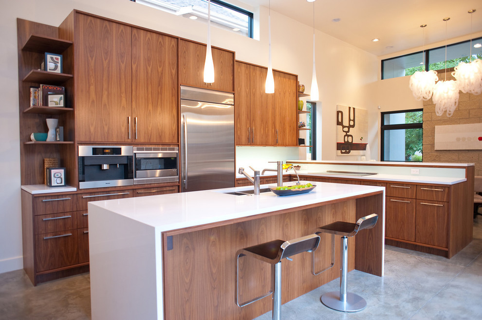 Eat-in kitchen - mid-sized modern l-shaped concrete floor and gray floor eat-in kitchen idea in Denver with a double-bowl sink, flat-panel cabinets, medium tone wood cabinets, quartz countertops, stainless steel appliances and an island
