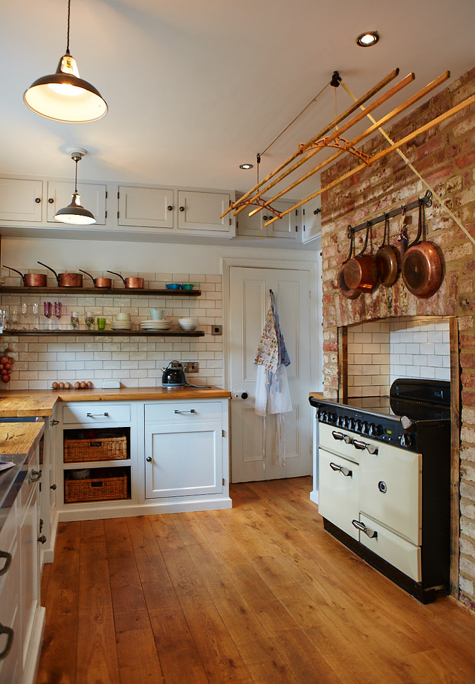 Exempel på ett mellanstort klassiskt brun brunt kök och matrum, med träbänkskiva, vitt stänkskydd, mellanmörkt trägolv, en rustik diskho, luckor med profilerade fronter, beige skåp och stänkskydd i keramik