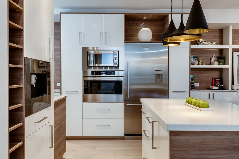 Small modern galley kitchen/diner in Toronto with a double-bowl sink, flat-panel cabinets, white cabinets, marble worktops, grey splashback, ceramic splashback, stainless steel appliances, light hardwood flooring and an island.