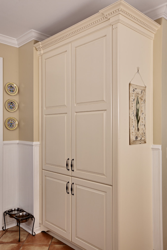 Mid-sized elegant u-shaped travertine floor and beige floor eat-in kitchen photo in Atlanta with raised-panel cabinets, beige cabinets, an undermount sink, granite countertops, beige backsplash, travertine backsplash, white appliances, an island and beige countertops