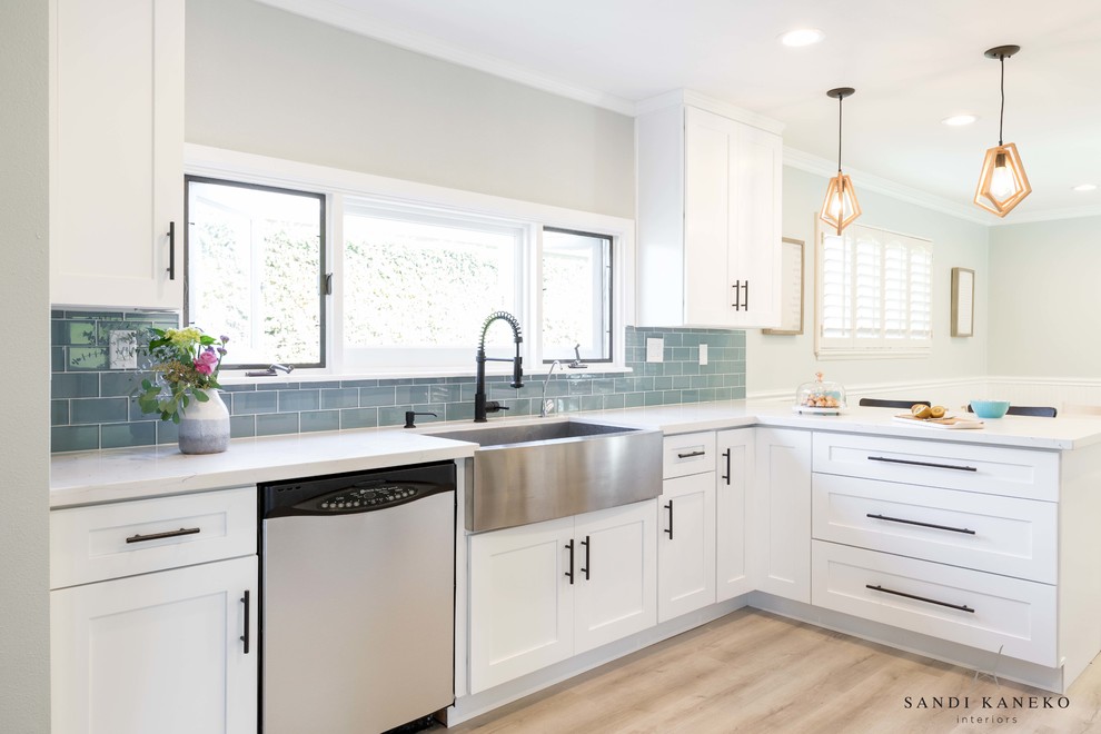Inspiration for a small modern galley light wood floor and gray floor eat-in kitchen remodel in Los Angeles with a farmhouse sink, shaker cabinets, white cabinets, quartz countertops, blue backsplash, glass tile backsplash, stainless steel appliances, a peninsula and white countertops