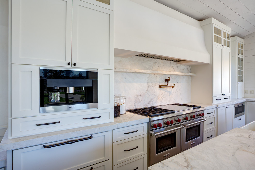 Mid-sized country galley ceramic tile eat-in kitchen photo in San Francisco with a drop-in sink, raised-panel cabinets, white cabinets, soapstone countertops, white backsplash, stone slab backsplash, stainless steel appliances and no island