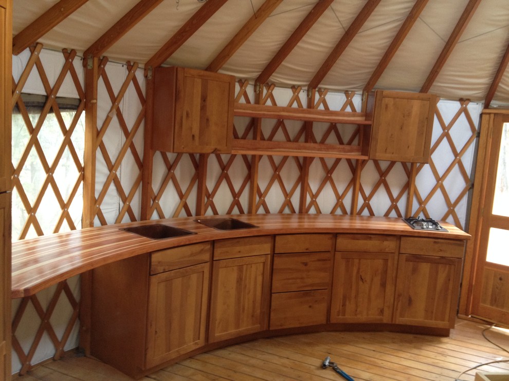 Aménagement d'une cuisine linéaire montagne en bois brun avec un placard à porte shaker et un plan de travail en bois.
