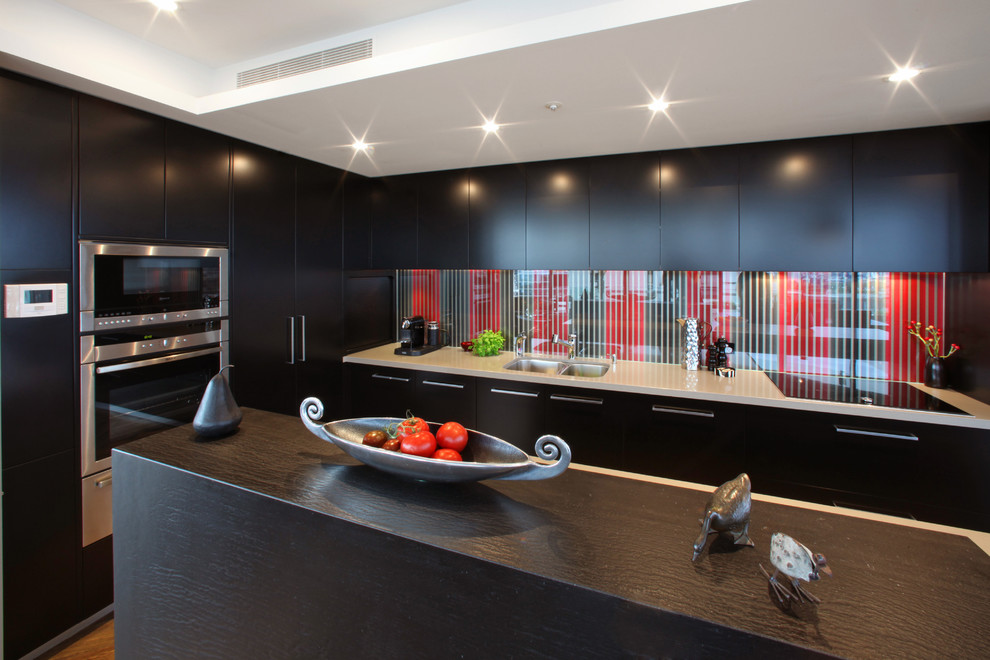 Источник вдохновения для домашнего уюта: кухня в стиле модернизм с плоскими фасадами, черными фасадами, разноцветным фартуком, фартуком из стекла и окном