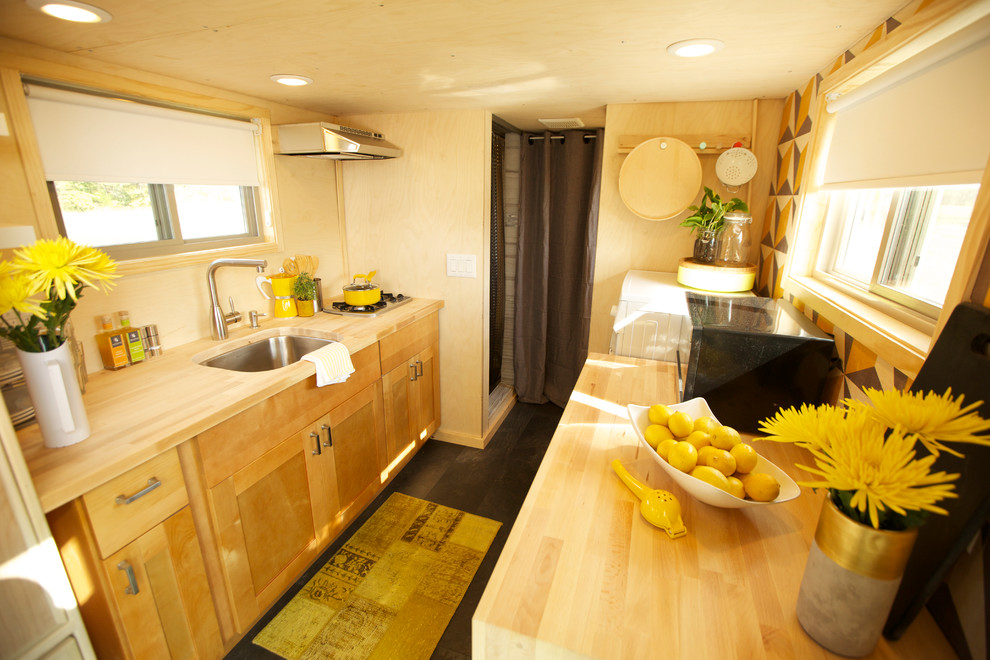 Example of a small trendy galley vinyl floor kitchen design in Other with flat-panel cabinets, medium tone wood cabinets, wood countertops, stainless steel appliances and an undermount sink