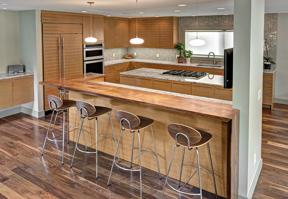 Moderne Küche in L-Form mit Unterbauwaschbecken, flächenbündigen Schrankfronten, hellbraunen Holzschränken, Küchenrückwand in Grau und Elektrogeräten mit Frontblende in Minneapolis