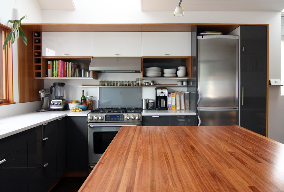 Moderne Küche mit offenen Schränken, schwarzen Schränken, Quarzwerkstein-Arbeitsplatte, Küchenrückwand in Grau, Glasrückwand und Küchengeräten aus Edelstahl in Seattle