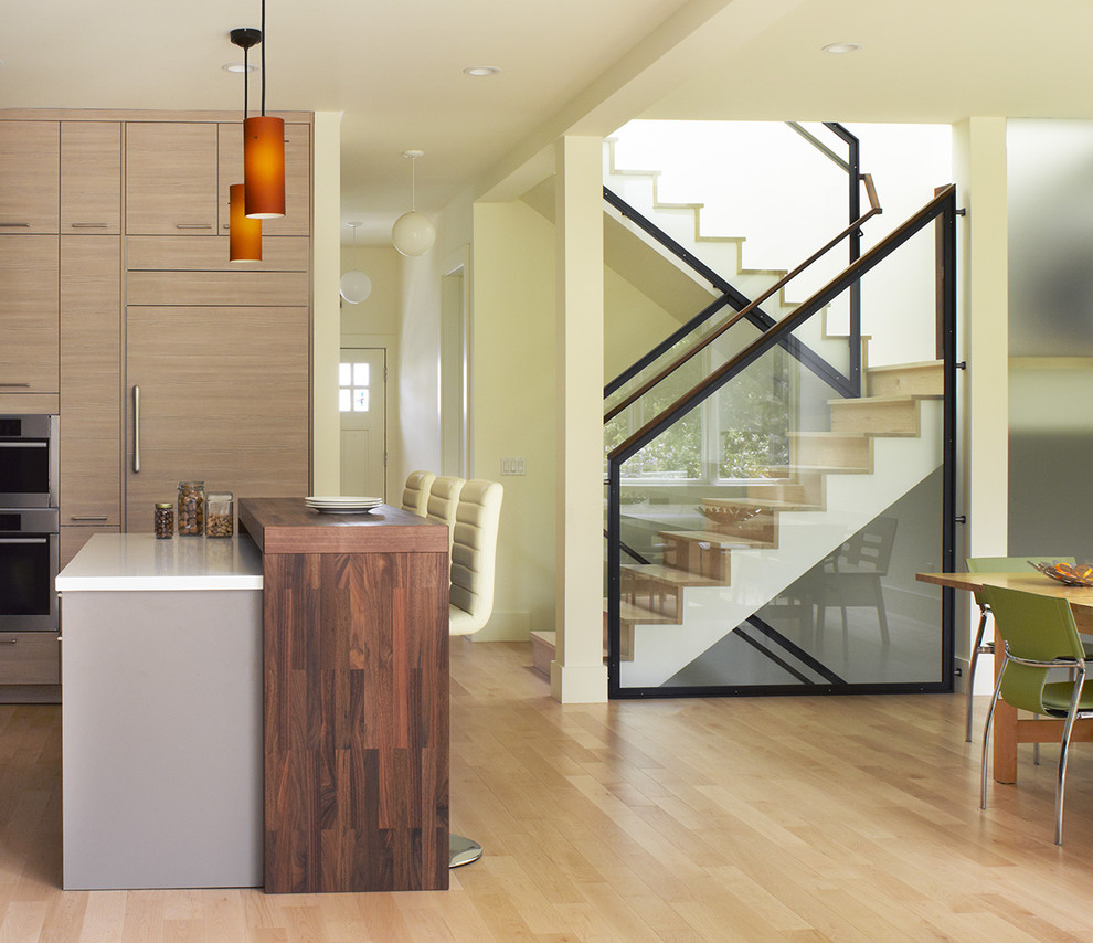 Immagine di una cucina abitabile moderna di medie dimensioni con top in legno, ante lisce, elettrodomestici da incasso, ante in legno chiaro, parquet chiaro, penisola e pavimento beige