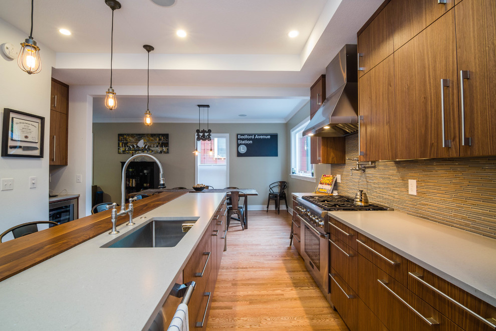 Eat-in kitchen - mid-sized contemporary galley light wood floor eat-in kitchen idea in Portland with flat-panel cabinets, dark wood cabinets, quartz countertops, stainless steel appliances and an island