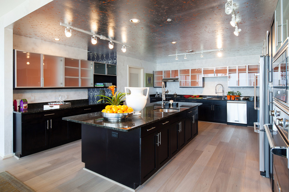 Example of a large urban light wood floor eat-in kitchen design in DC Metro with an island, flat-panel cabinets, dark wood cabinets, granite countertops, beige backsplash, cement tile backsplash, stainless steel appliances and a drop-in sink