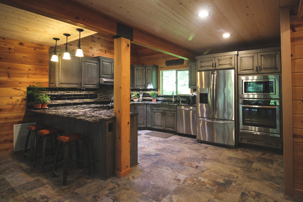 Bild på ett stort rustikt kök, med en dubbel diskho, luckor med upphöjd panel, grå skåp, granitbänkskiva, flerfärgad stänkskydd, stänkskydd i stickkakel, rostfria vitvaror, klinkergolv i keramik och flerfärgat golv