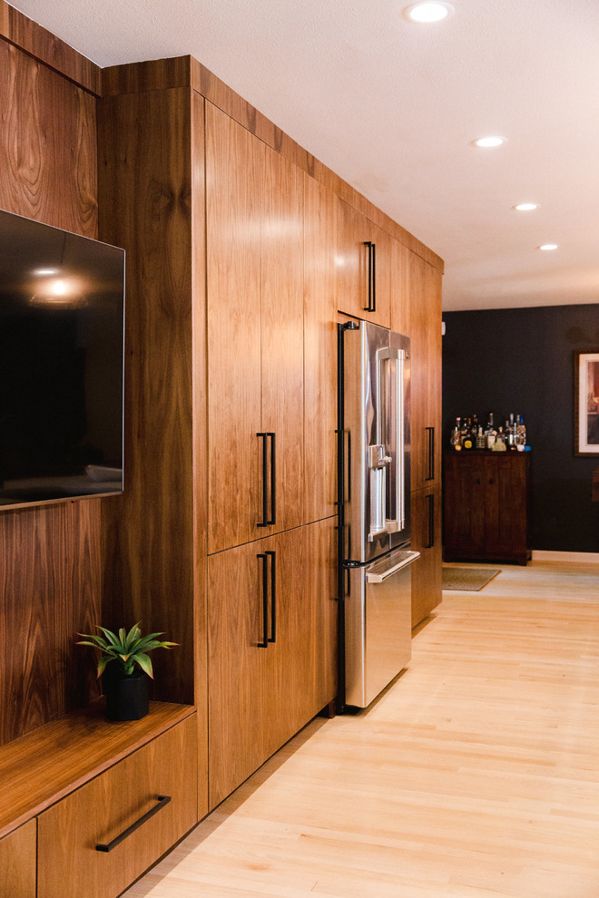オースティンにある高級な広いコンテンポラリースタイルのおしゃれなキッチン (ダブルシンク、フラットパネル扉のキャビネット、濃色木目調キャビネット、黒い調理設備、淡色無垢フローリング、ベージュの床、茶色いキッチンカウンター) の写真