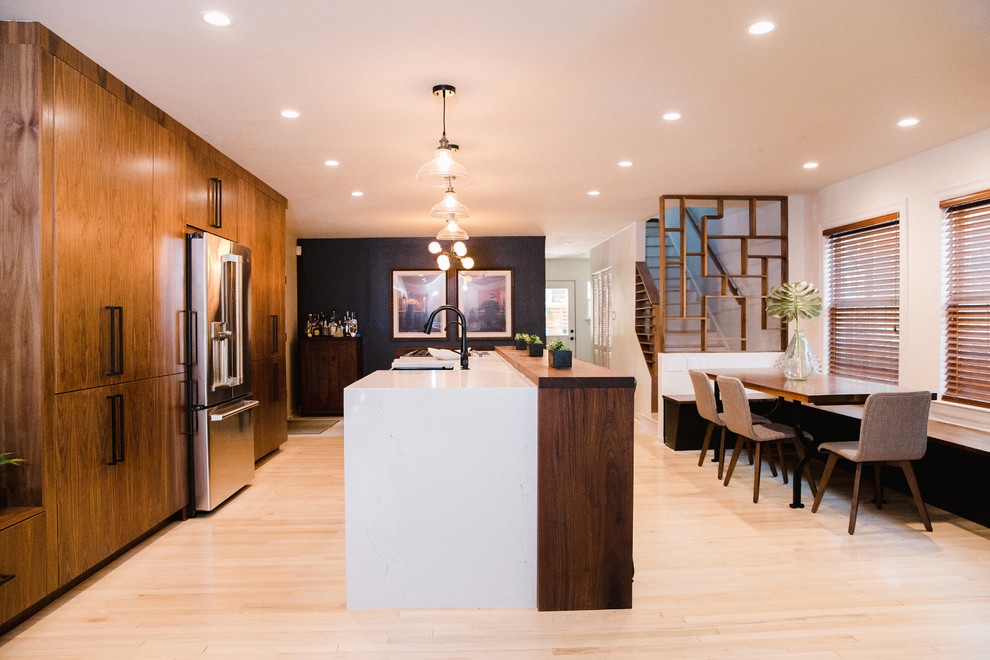 Eat-in kitchen - large contemporary single-wall light wood floor and beige floor eat-in kitchen idea in Austin with a double-bowl sink, dark wood cabinets, flat-panel cabinets, black appliances, an island and brown countertops