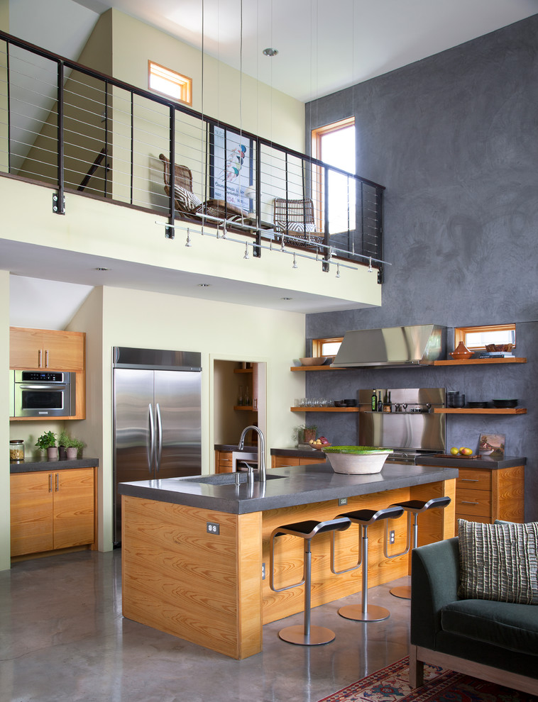 Exempel på ett modernt kök med öppen planlösning, med en integrerad diskho, öppna hyllor, skåp i mellenmörkt trä, rostfria vitvaror, betonggolv och en köksö
