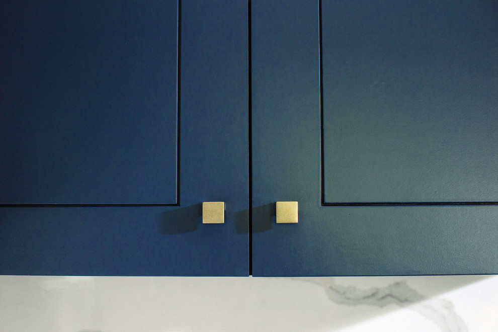 Immagine di una cucina classica di medie dimensioni con lavello sottopiano, ante lisce, ante blu, top in quarzo composito, paraspruzzi bianco, elettrodomestici in acciaio inossidabile, pavimento in cementine, pavimento grigio e top bianco