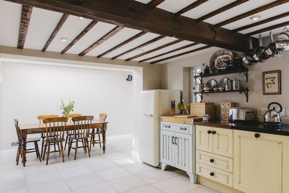 Imagen de cocina de estilo de casa de campo de obra con puertas de armario amarillas