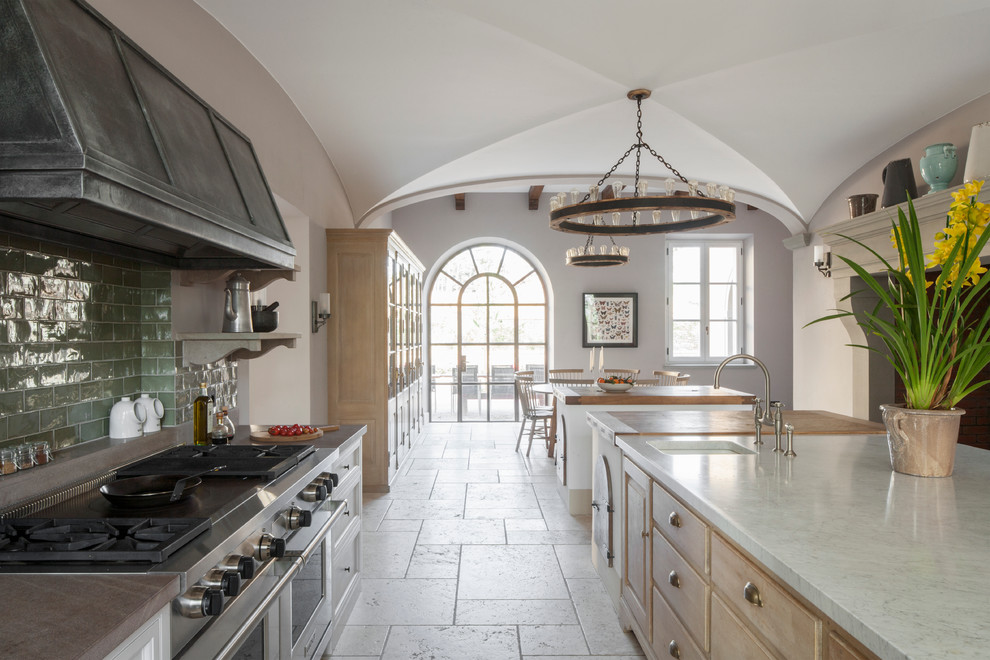 Inspiration for a large country u-shaped limestone floor eat-in kitchen remodel in London with light wood cabinets, marble countertops, green backsplash, subway tile backsplash, stainless steel appliances and two islands
