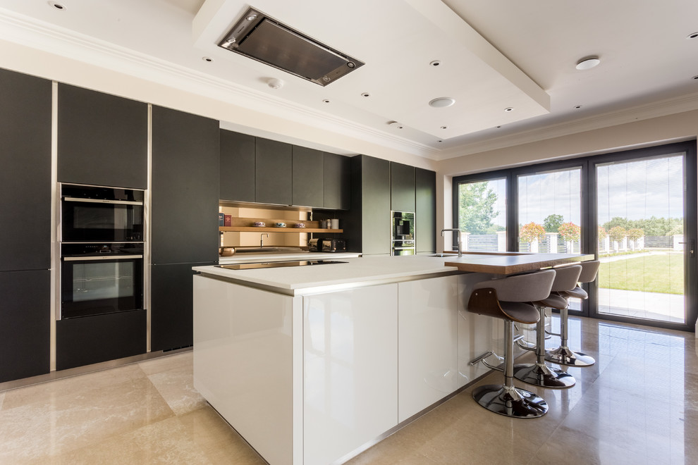 Foto di una cucina design di medie dimensioni con ante lisce, top in quarzite, pavimento beige, top bianco, lavello sottopiano, ante nere, elettrodomestici neri e paraspruzzi a effetto metallico
