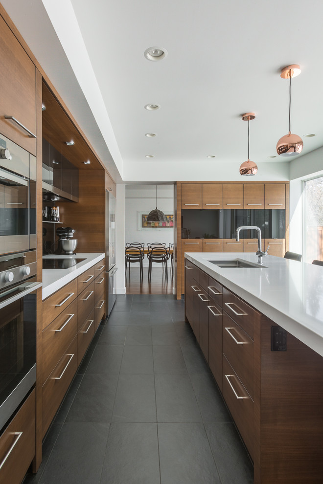 Design ideas for a contemporary l-shaped kitchen in Other with a submerged sink, flat-panel cabinets, medium wood cabinets, stainless steel appliances, an island, grey floors and white worktops.